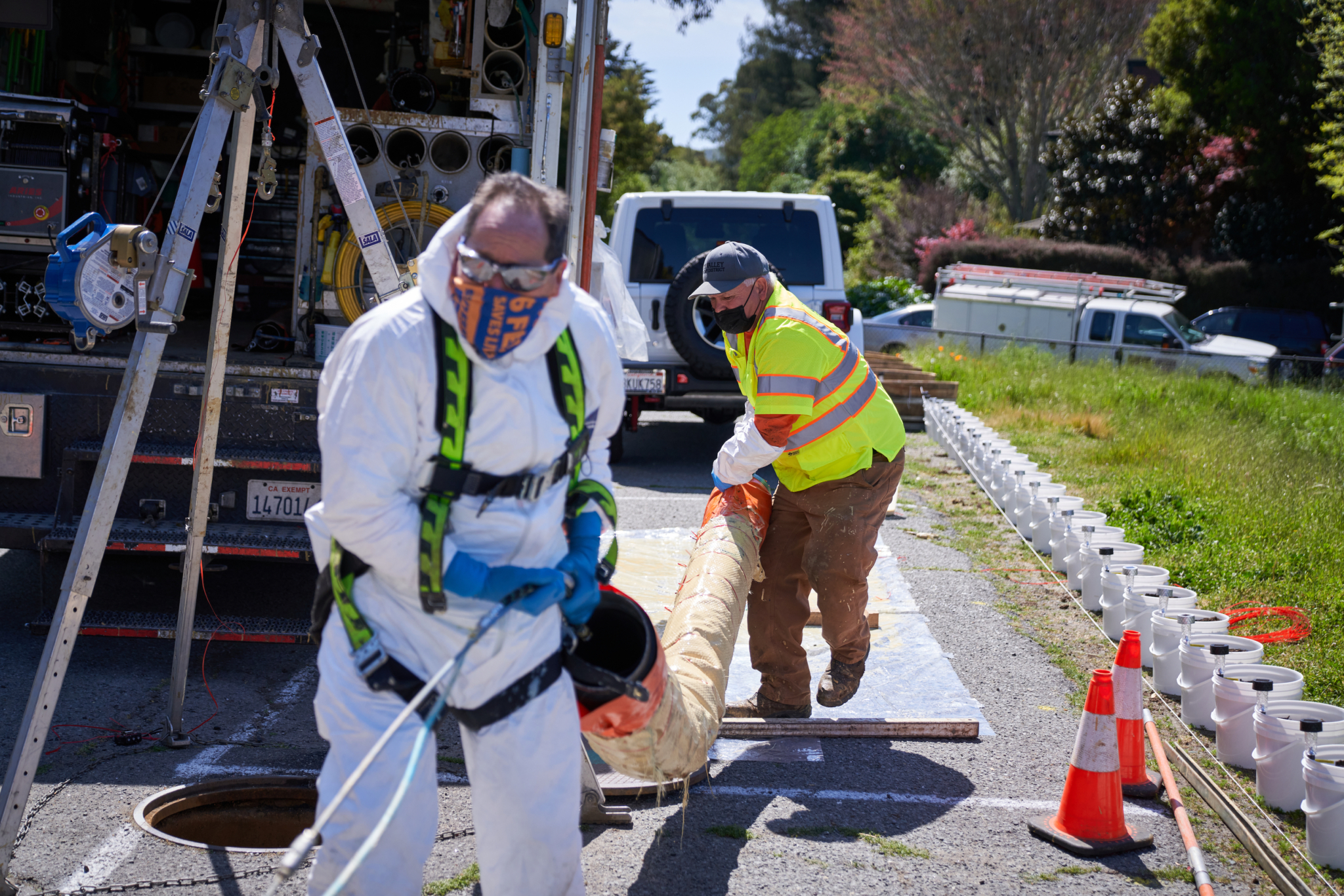 Collections Assistant Dale Olsen (right) and crew lead Frank Sousa hustle to get a patch carrier into a manhole for a repair. RSVD repair crews work in one of California's oldest wastewater utilities, with clay pipes as old as 50 years, requiring patching, updating and replacement.